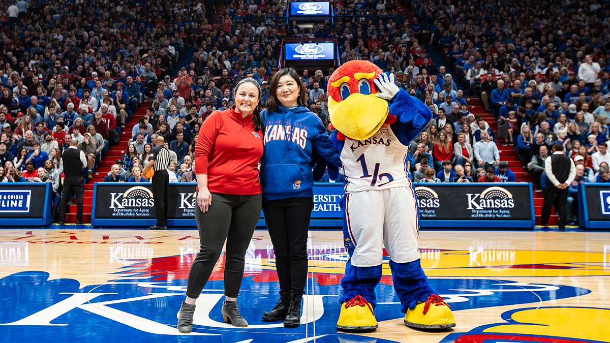 Belinda Sturm (Vice Chancellor for Research), Hui Cai (professor of architecture), and Baby Jay at Allen Fieldhouse. 