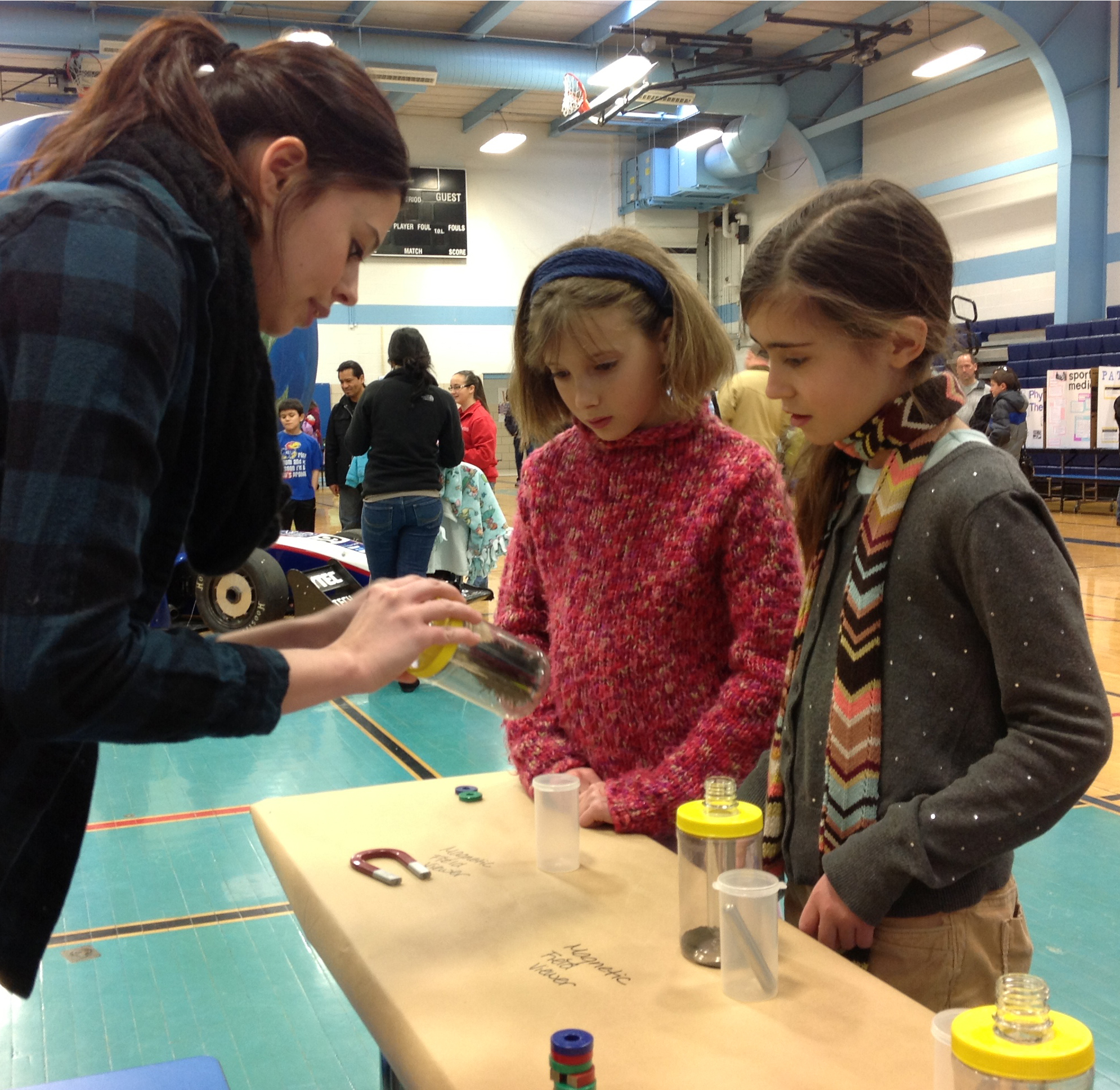 Two elementary school students listen to a KU scientist explain principles of energy.