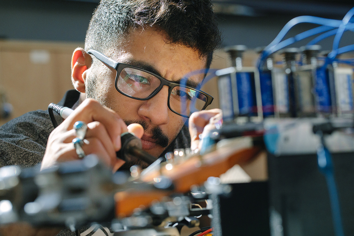 A researcher works closely with wires