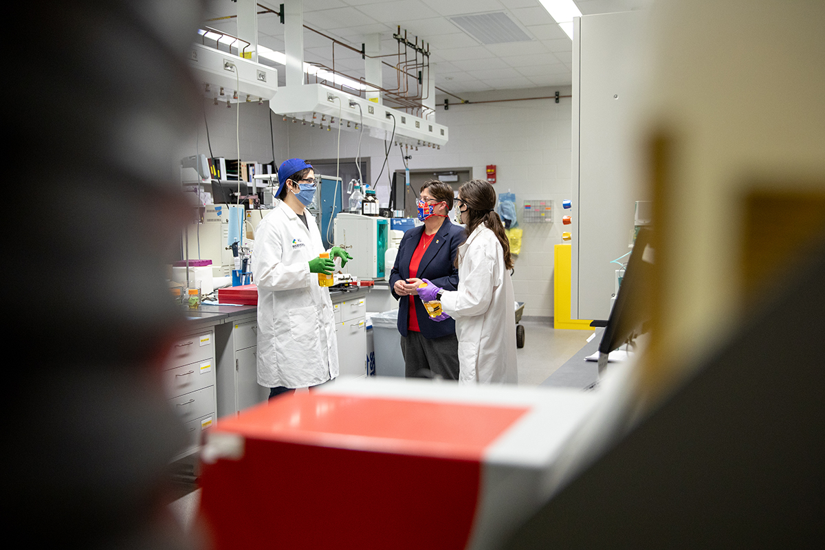 Three researchers talk in a biodiesel lab at KU