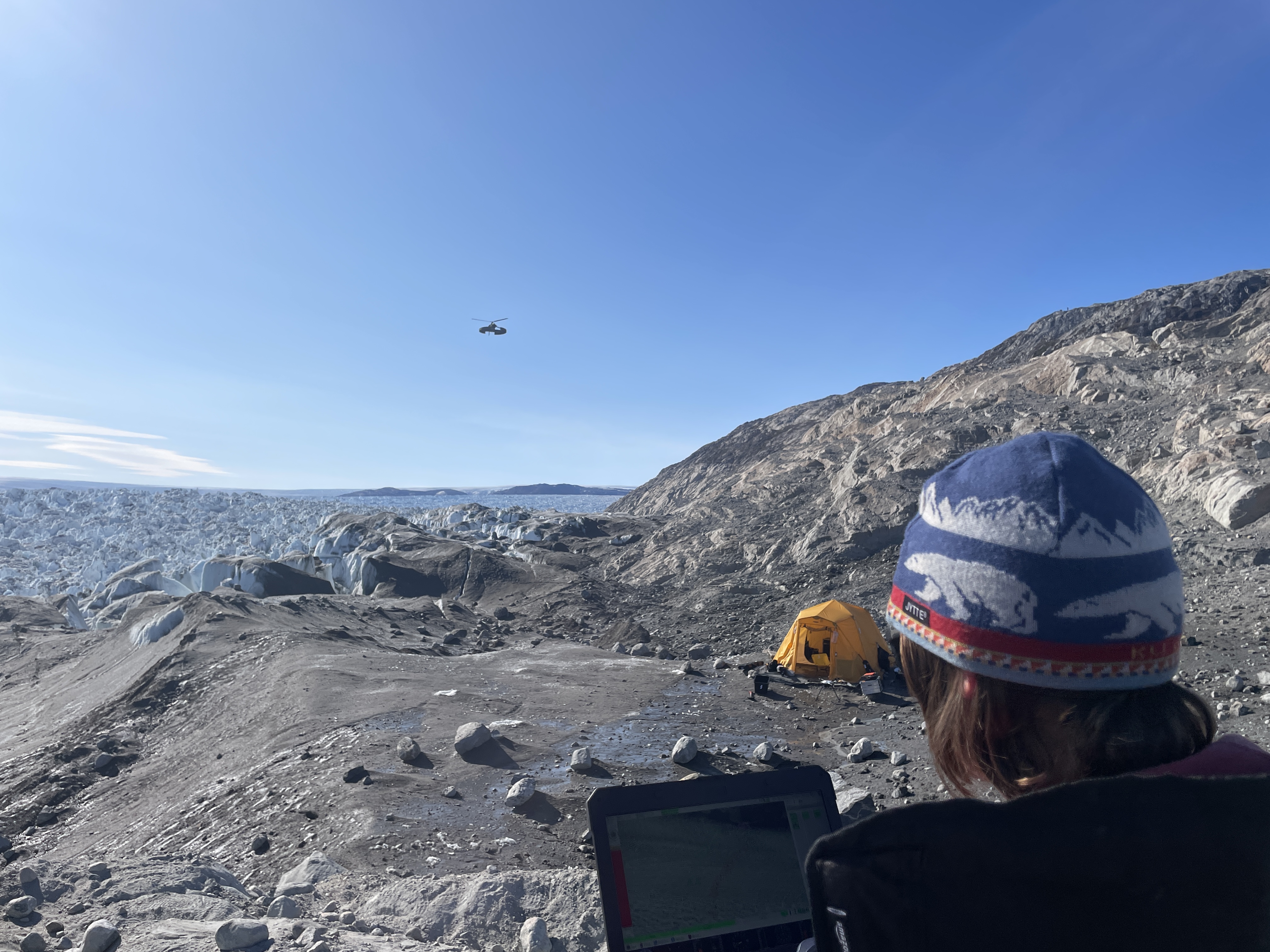 "Researchers pilot a drone flying over the glacier. "